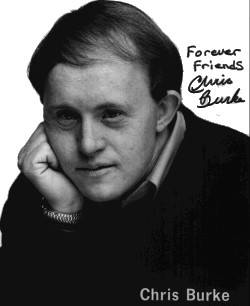 Foto Chris Burke: Foto seorang pria dengan wajah yang khas, ia tersenyum dengan mata yang bersinar.